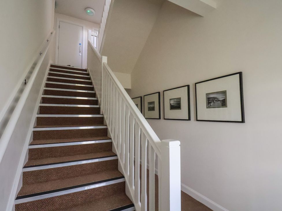 A staircase with framed pictures on the wall at Larpool Retreat 