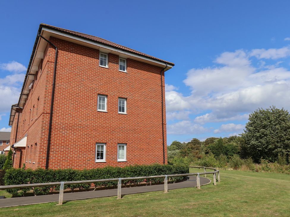 A brick building with windows and bushes in front at Larpool Retreat 