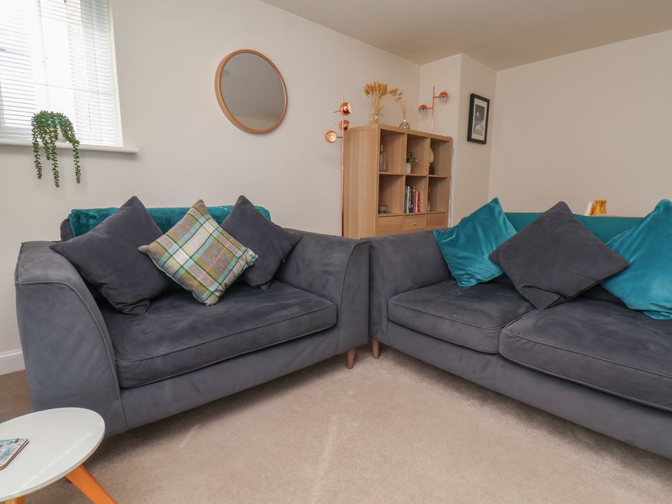 A living room with sofas and a bookshelf at Larpool Retreat in Whitby