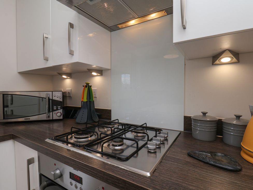 A kitchen featuring a gas stove and microwave at Larpool Retreat Whitby