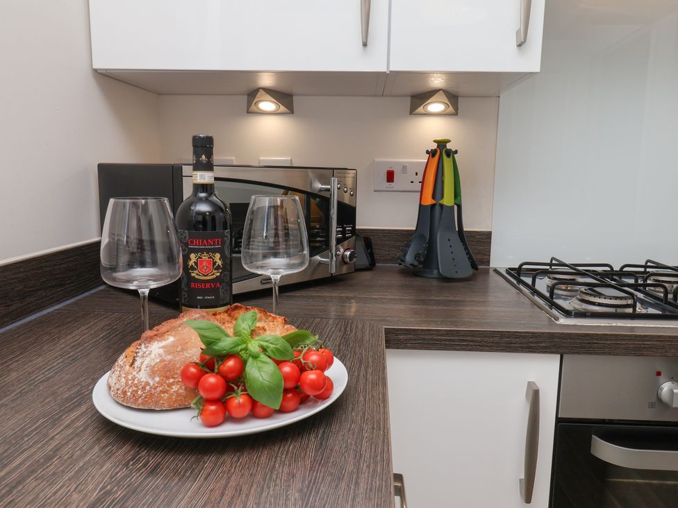 A kitchen with wine glasses, bread, and tomatoes at Larpool Retreat in Whitby