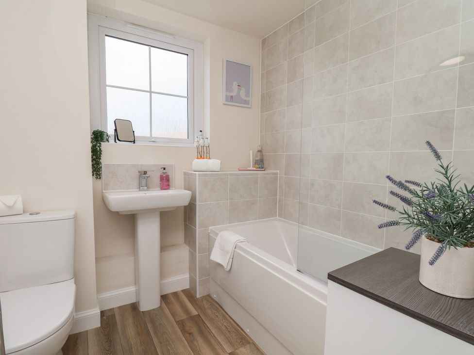 A bathroom featuring a bath, toilet, and sink at Larpool Retreat in Whitby
