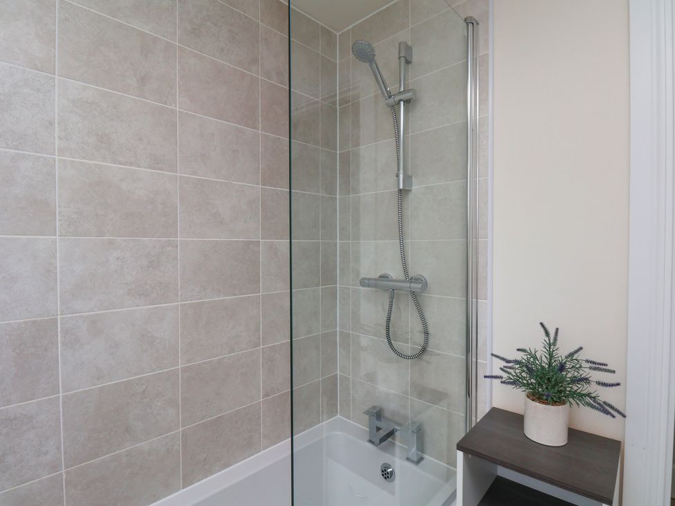 A bathroom with a shower and bathtub at Larpool Retreat in Whitby