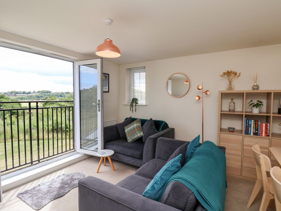 A living room with a sofa and bookshelf at Larpool Retreat in Whitby