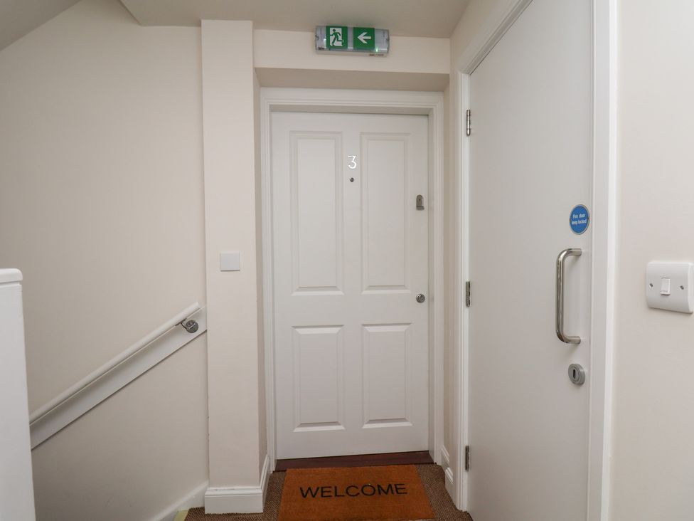 A hallway with a door and welcome mat at Larpool Retreat in Whitby