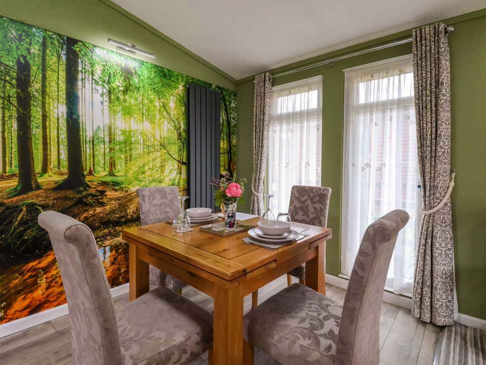 A dining room with a wooden table and chairs at Badgers Retreat - Two Dales in Richmond