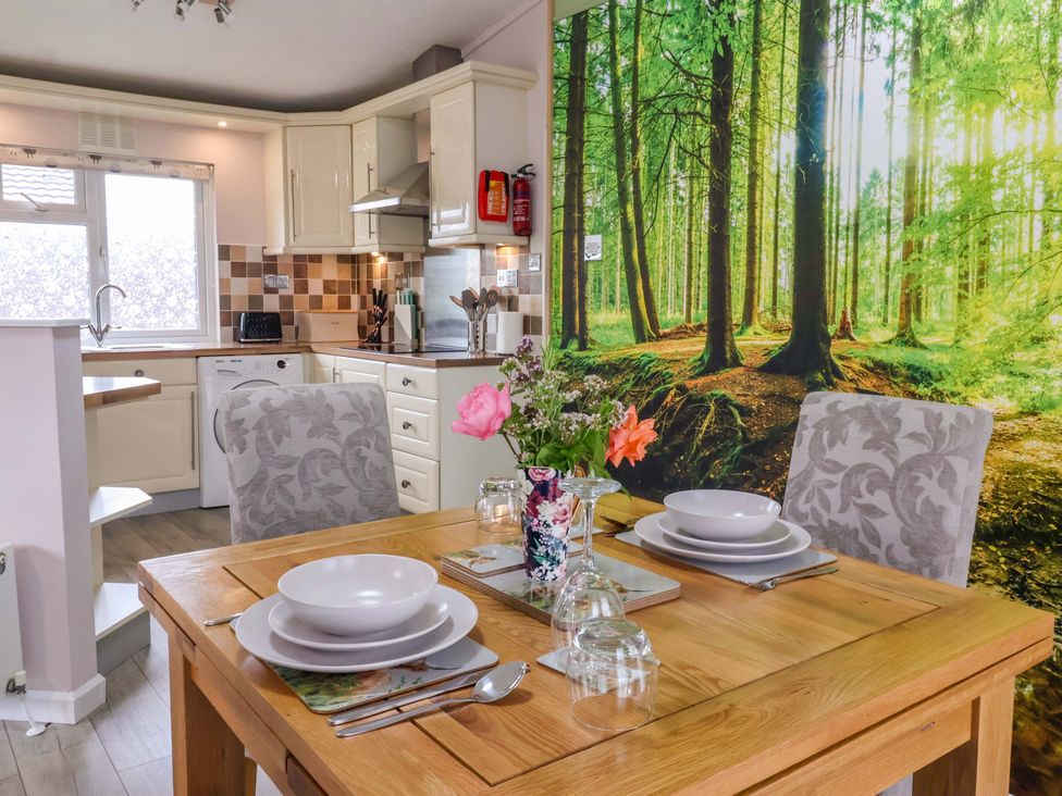 A dining area with a wood table and chairs at Badgers Retreat - Two Dales, Richmond