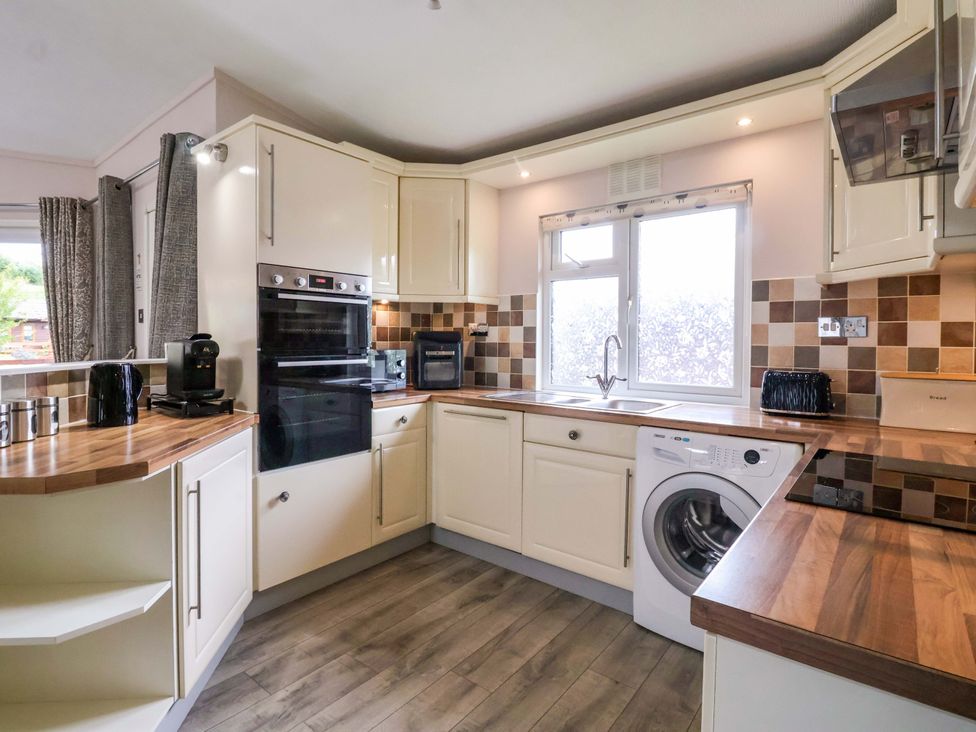 A kitchen with an oven, sink, and washing machine at Badgers Retreat - Two Dales in Richmond