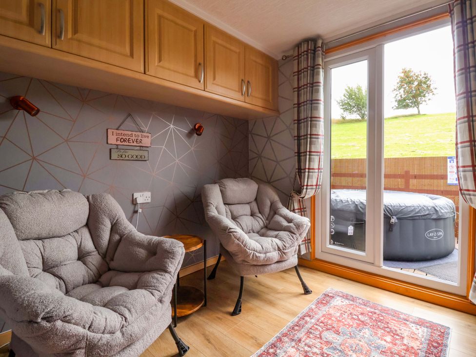 A snug with two armchairs and a window at Badgers Retreat - Two Dales Richmond