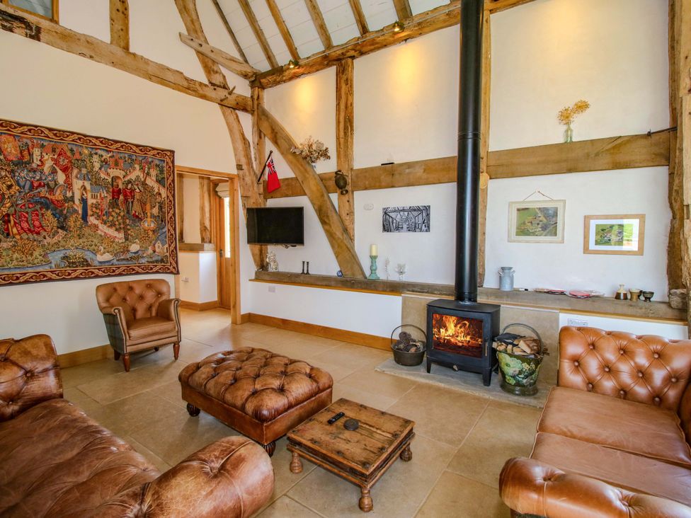 A living room with a fireplace and tapestry at Crook Barn in Tenbury Wells