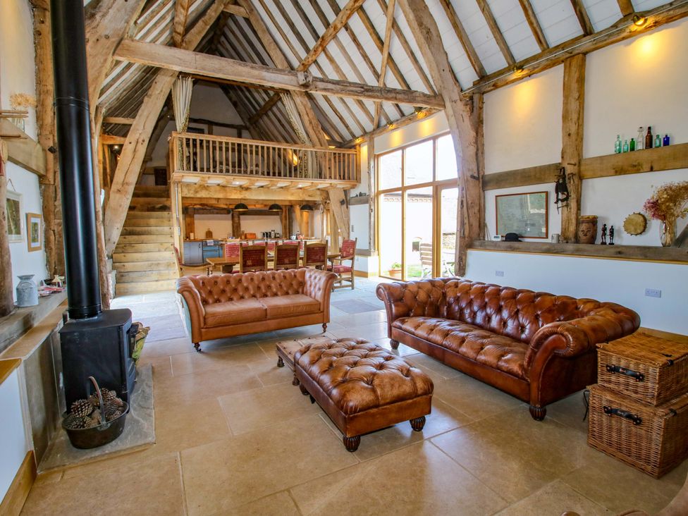 A living room with sofas and a fireplace at Crook Barn in Tenbury Wells