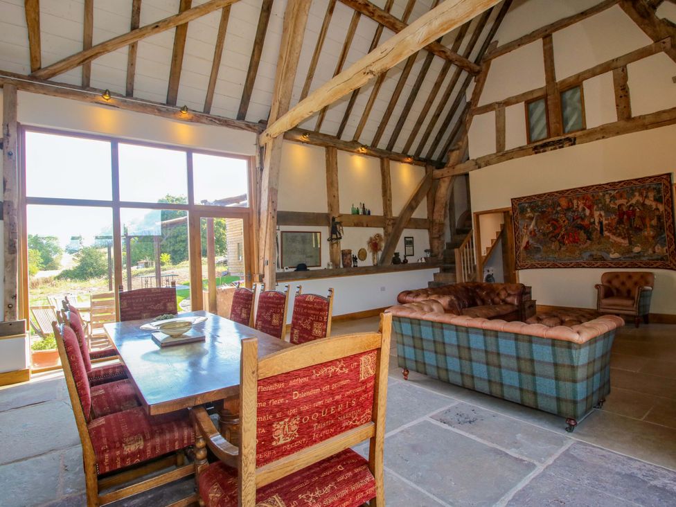 A living room with a dining table and sofa at Crook Barn in Tenbury Wells