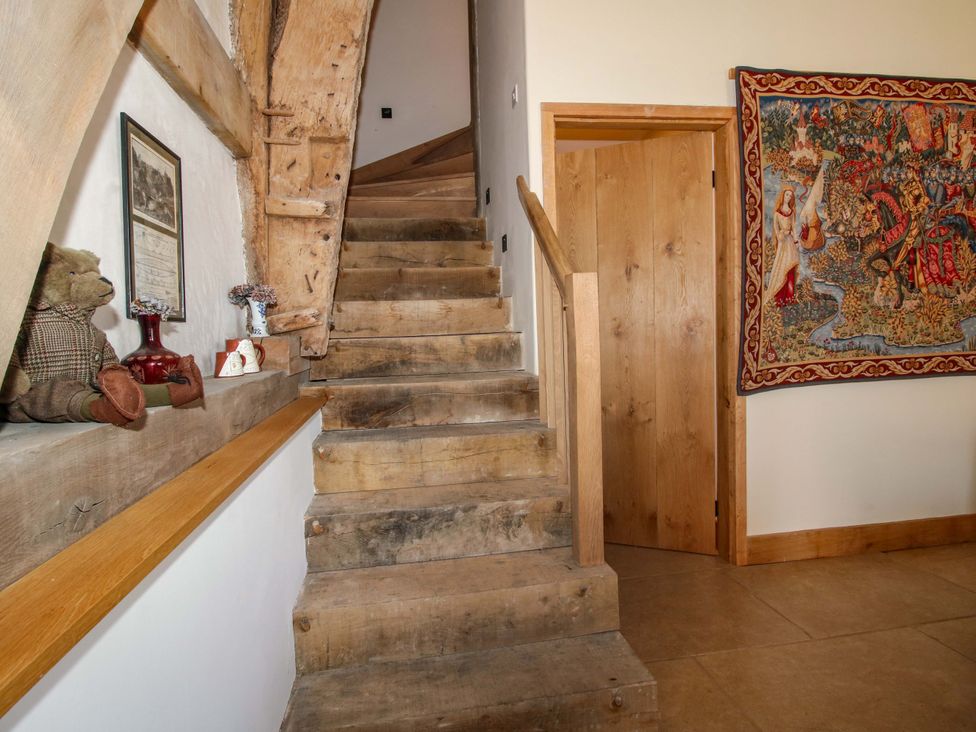 A hallway with stairs and tapestry at Crook Barn in Tenbury Wells