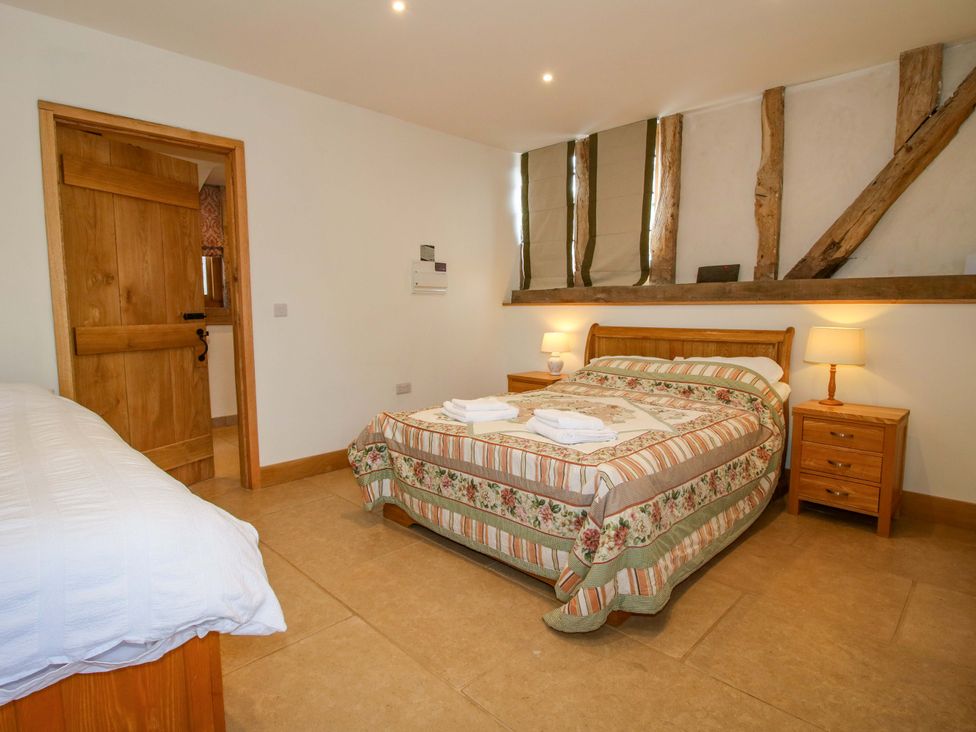 A bedroom with a bed and bedside tables at Crook Barn Tenbury Wells