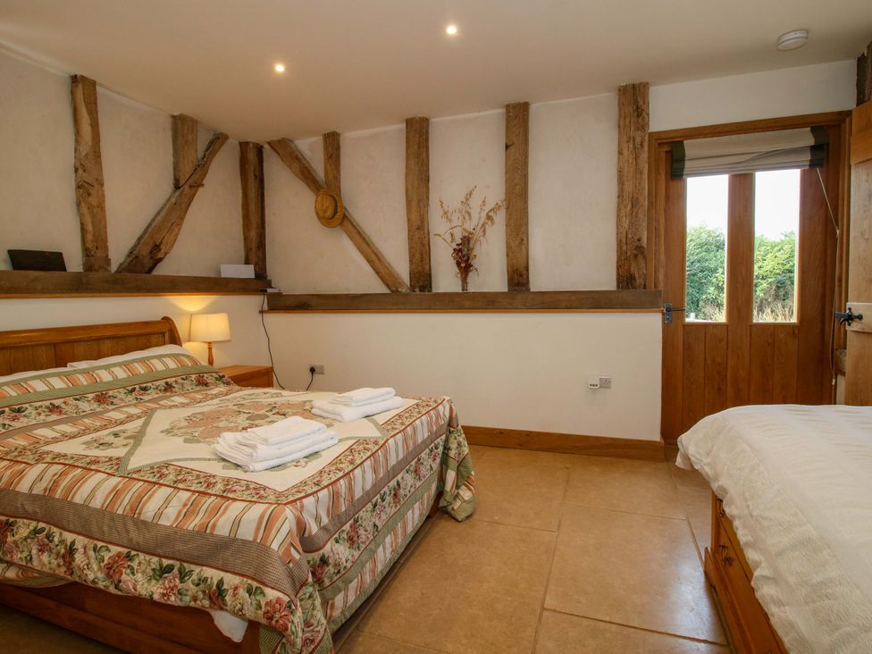 A bedroom with a bed and a window at Crook Barn Tenbury Wells