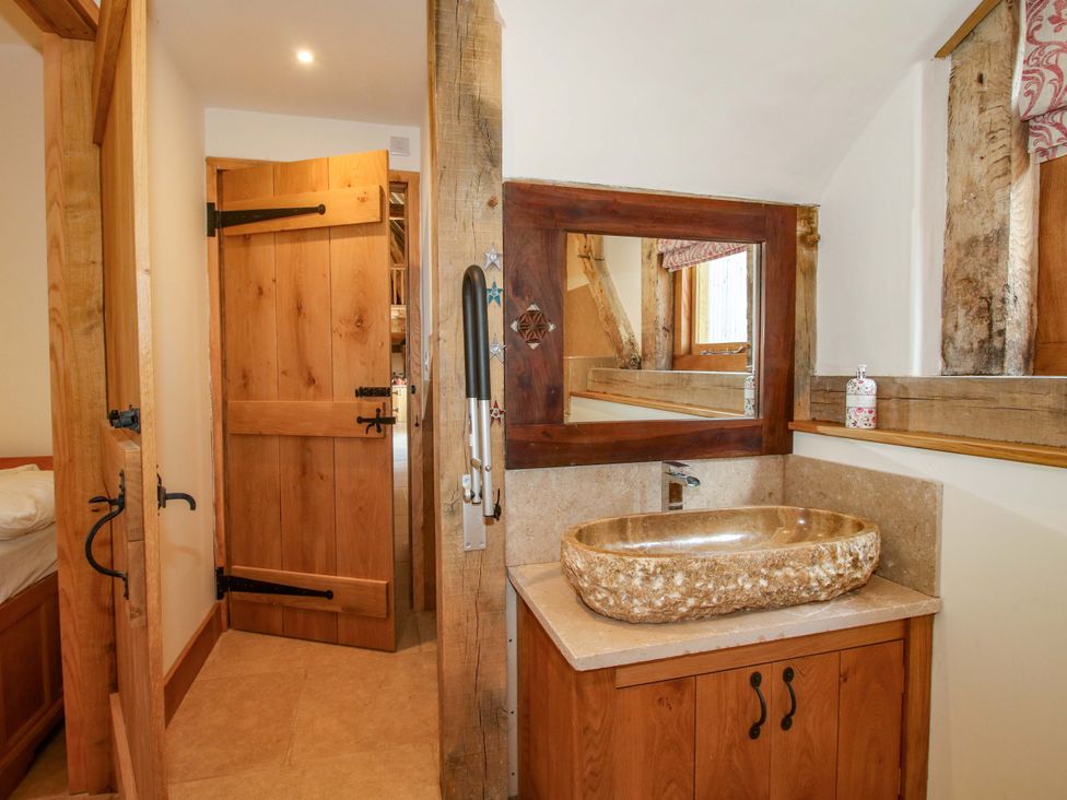 A bathroom featuring a wooden door and a stone sink at Crook Barn Tenbury Wells