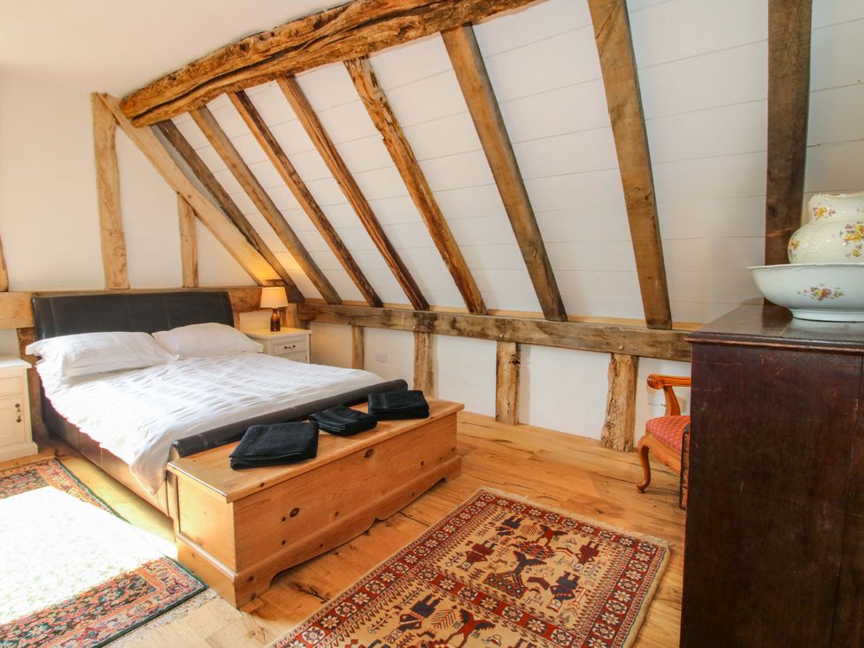 A bedroom with wooden beams and a bed at Crook Barn in Tenbury Wells