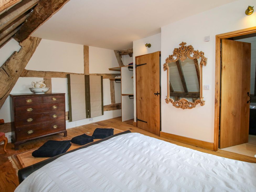 A bedroom with a bed and a dresser at Crook Barn in Tenbury Wells