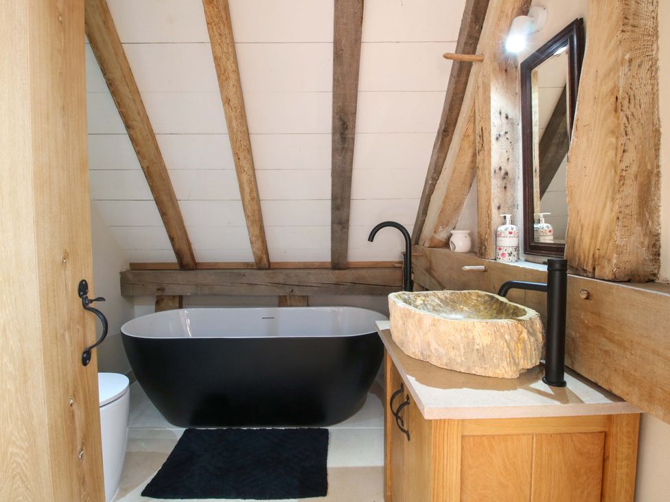 A bathroom with a bathtub and sink at Crook Barn in Tenbury Wells