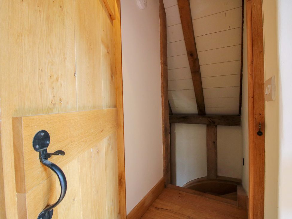A staircase leading to a wooden door at Crook Barn Tenbury Wells