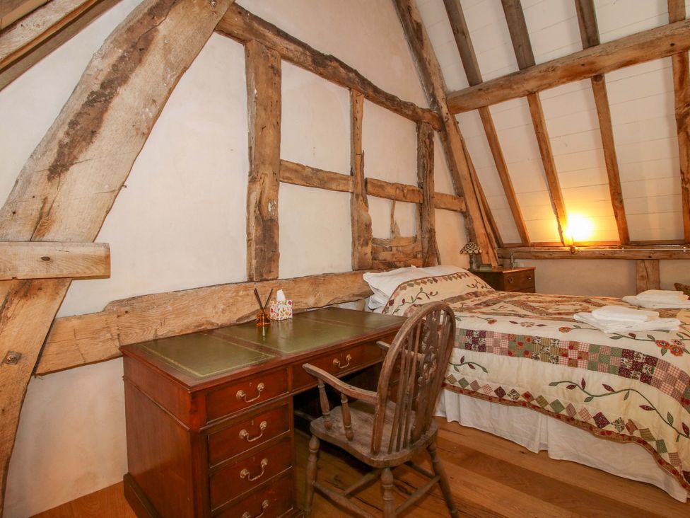A bedroom with a bed and desk at Crook Barn Tenbury Wells