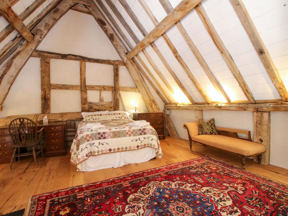 A bedroom with a bed and dresser at Crook Barn Tenbury Wells
