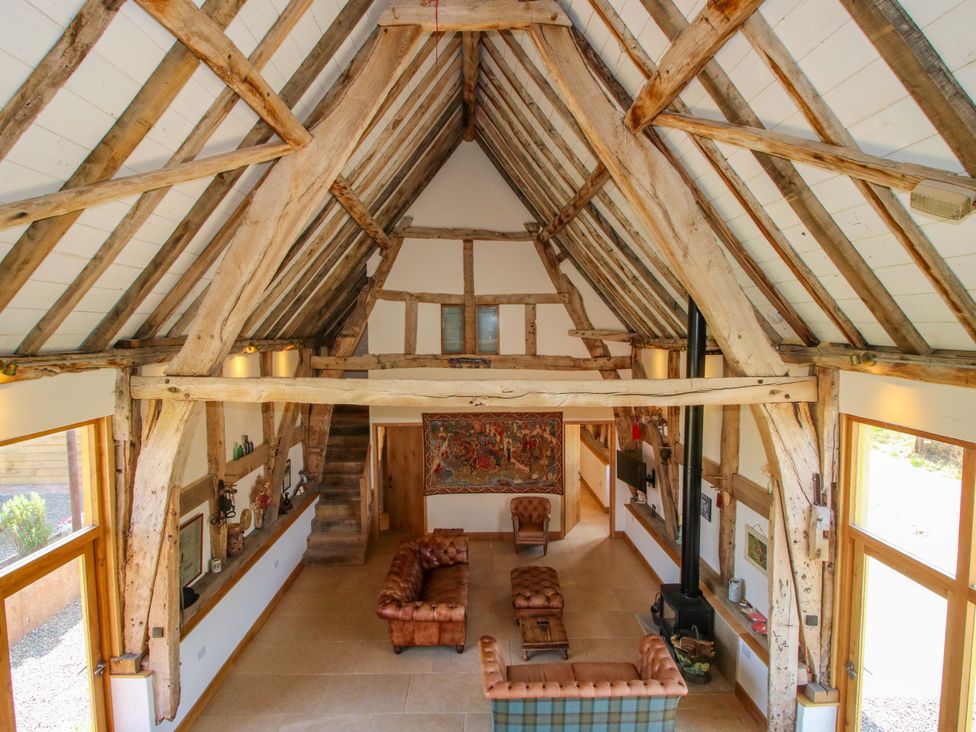 A living room with beams and a fireplace at Crook Barn in Tenbury Wells