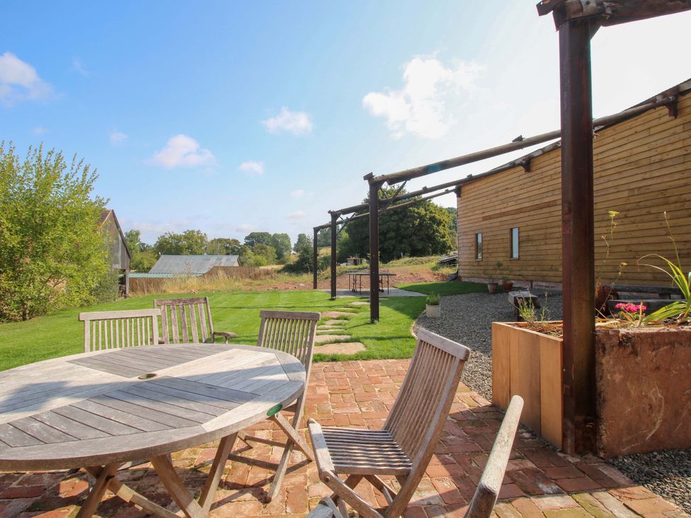A garden with a table and chairs at Crook Barn in Tenbury Wells