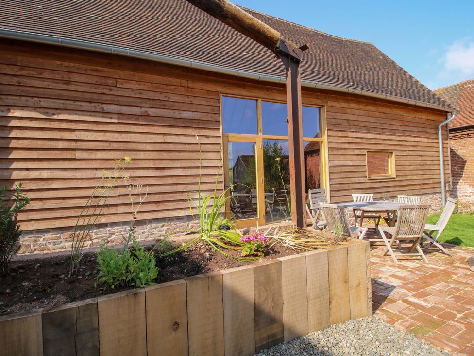 An outdoor patio area with a table and chairs at Crook Barn in Tenbury Wells