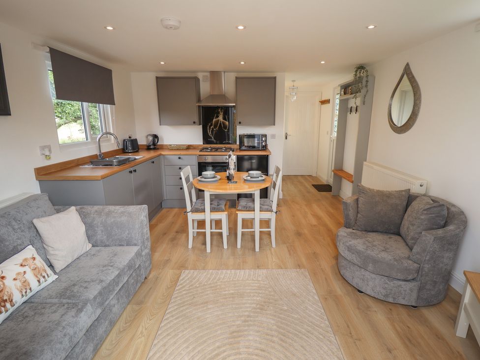A kitchen with dining table and seating area at Pear Tree Lodge in Alford