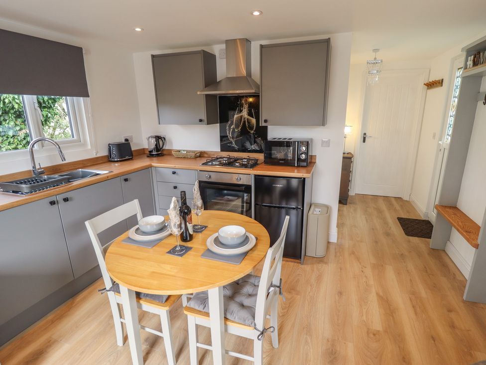 A kitchen with a table and chairs at Pear Tree Lodge in Alford