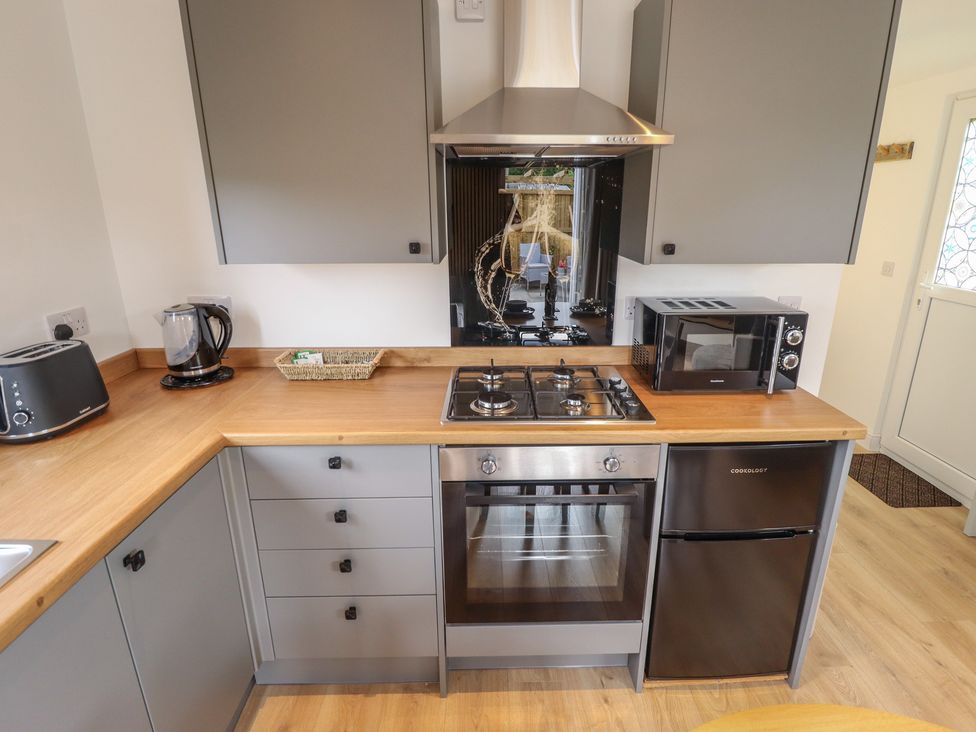 A kitchen with appliances and cabinets at Pear Tree Lodge in Alford