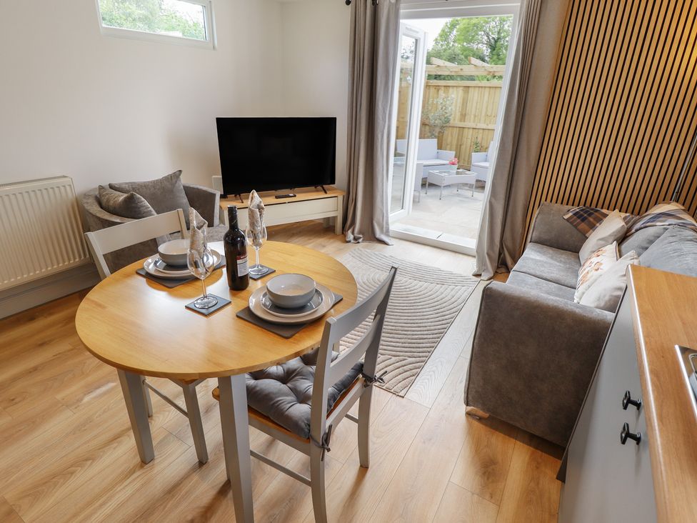 A living room with a table, chairs, and a sofa at Pear Tree Lodge in Alford