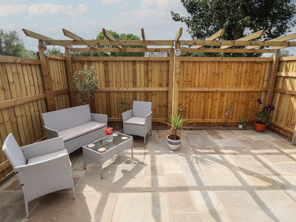An outdoor seating area with furniture and plants at Pear Tree Lodge in Alford