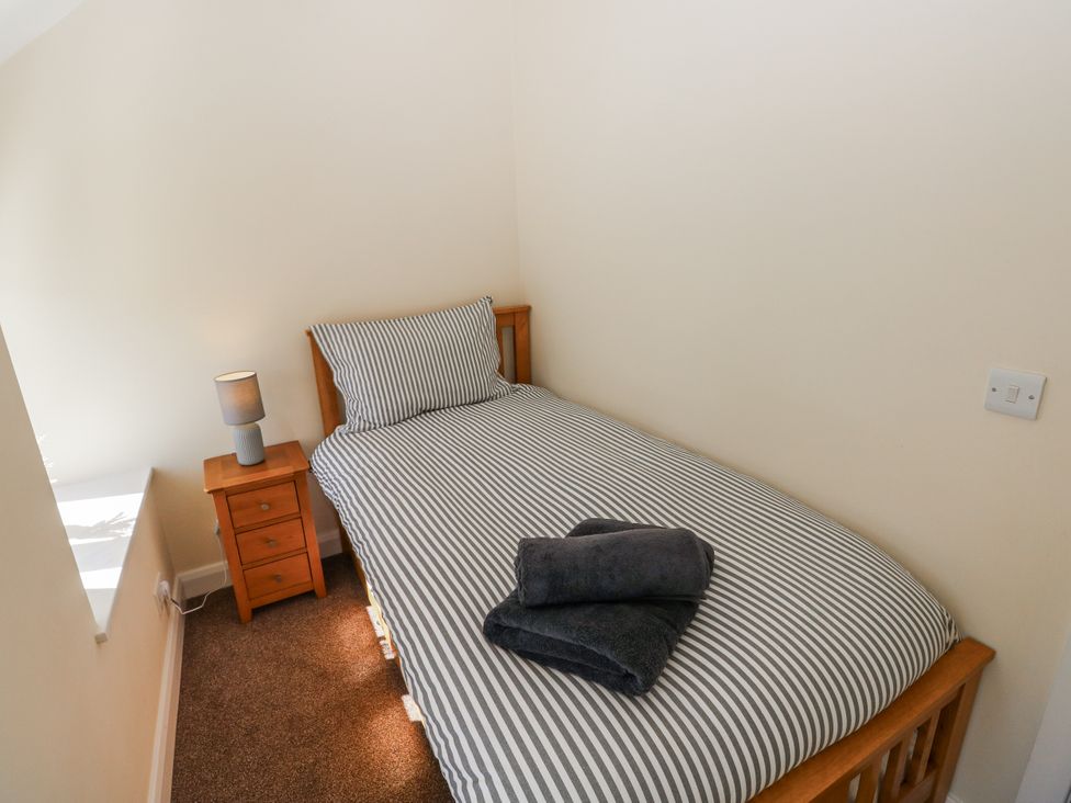 A bedroom with a single bed and bedside table at Vern Dale in Builth Wells