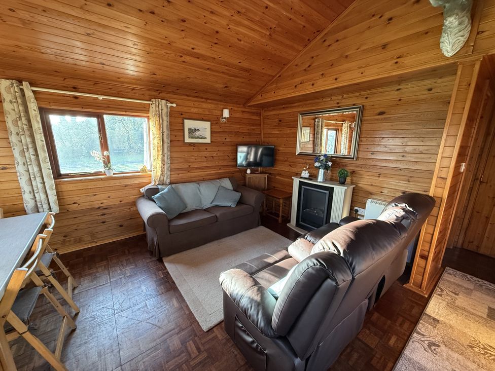 A living room with a sofa and television at Oak Lodge in Mynydd Cerrig near Porthyrhyd