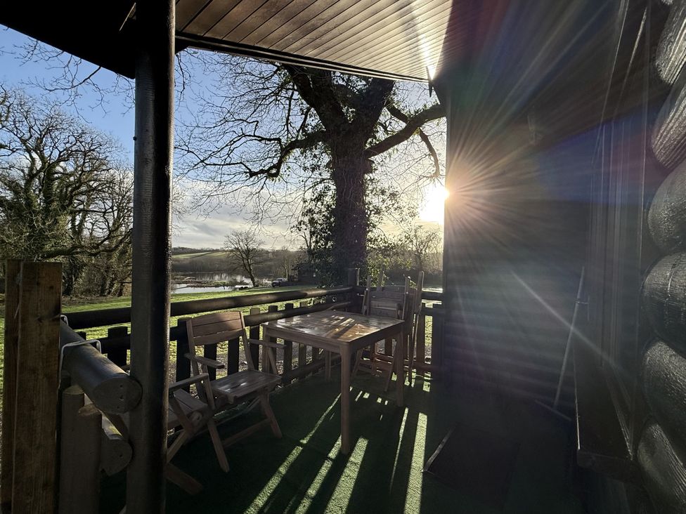An outdoor patio with a table and chairs at Oak Lodge in Mynydd Cerrig near Porthyrhyd