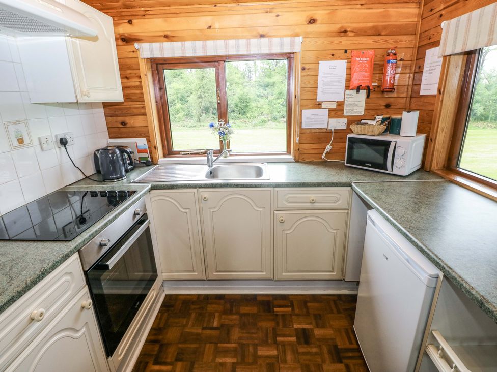 A kitchen with a sink and appliances at Oak Lodge Mynydd Cerrig near Porthyrhyd