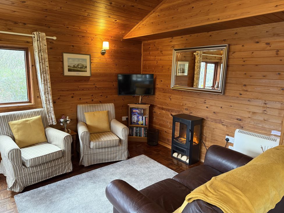 A living room with a sofa and armchairs at Ash Lodge near Mynydd Cerrig