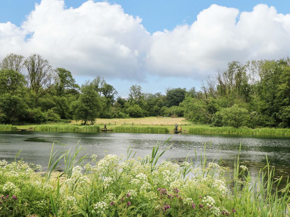 A lake with fishermen and vegetation at Ash Lodge, Mynydd Cerrig near Porthyrhyd