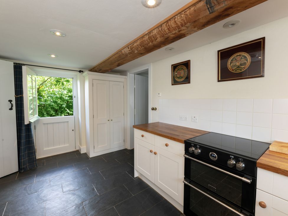 A kitchen with cabinets and an oven at West Cottage Llandovery