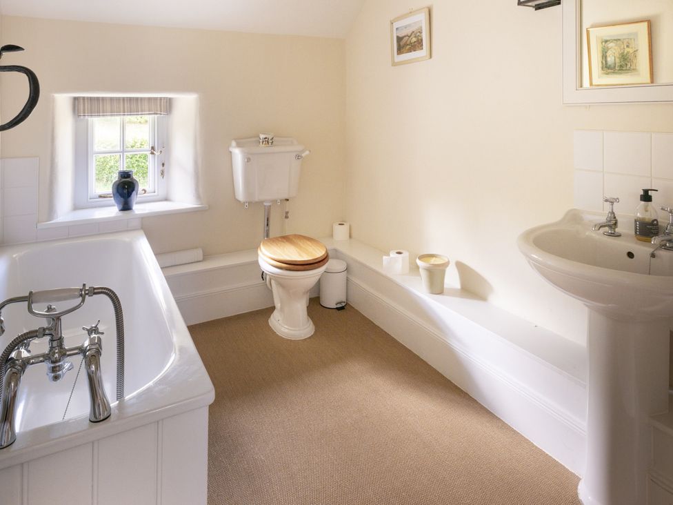 A bathroom with a bathtub, toilet, and sink at West Cottage in Llandovery