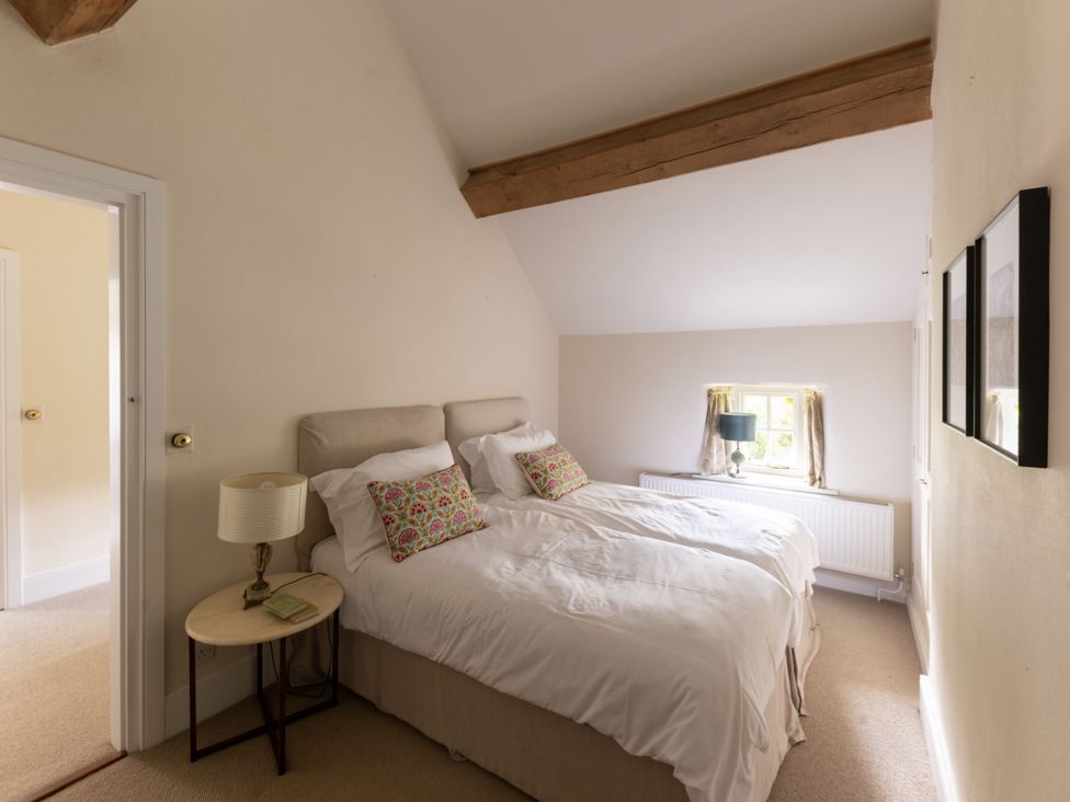 A bedroom with two beds and a lamp at West Cottage in Llandovery