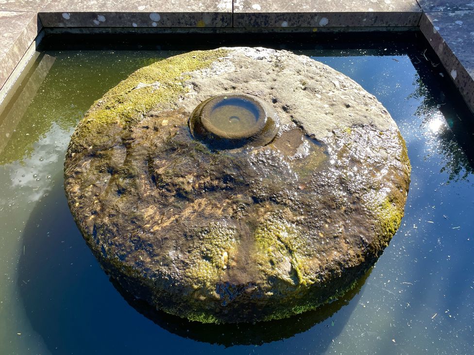 A stone fountain in water at West Cottage Myddfai near Llandovery