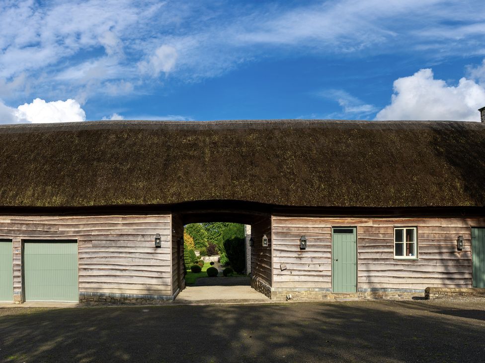 A building with a thatched roof and green doors at West Cottage Myddfai near Llandovery