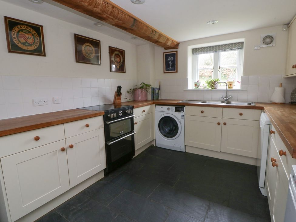 A kitchen with an oven and washing machine at West Cottage near Llandovery