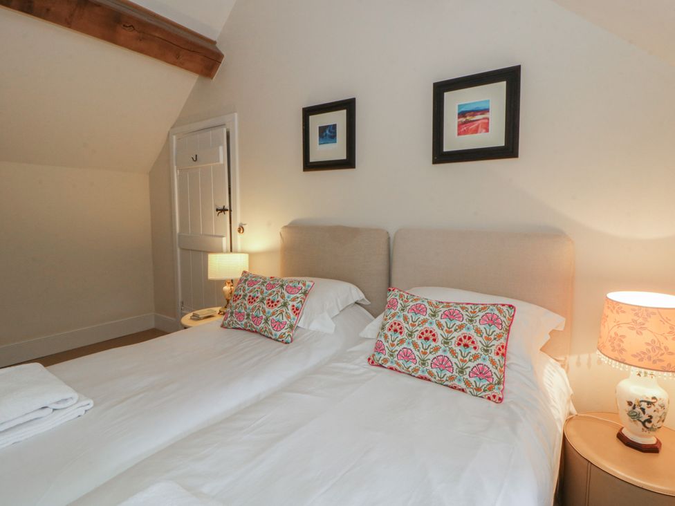 A bedroom with two beds and a lamp at West Cottage in Myddfai near Llandovery