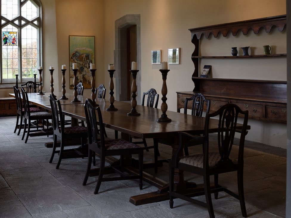 A dining room with a long table and chairs at West Cottage in Myddfai near Llandovery