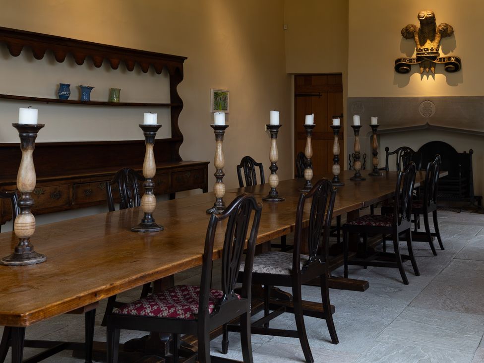 A dining room with a long table and chairs at West Cottage Myddfai near Llandovery
