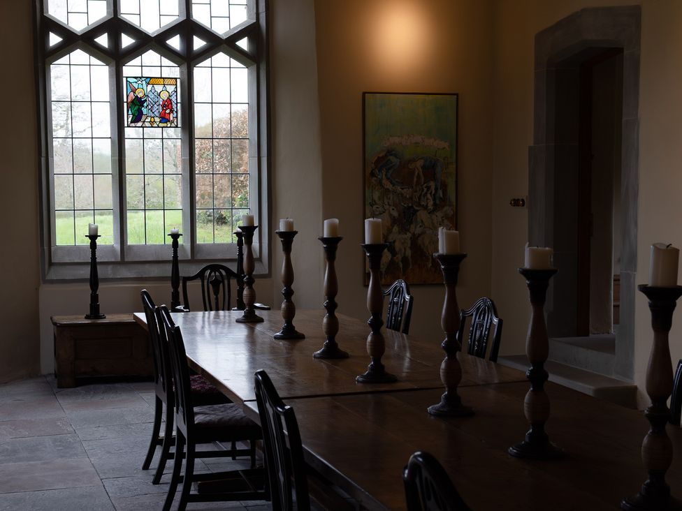 A dining room with a long table and candles at West Cottage in Myddfai near Llandovery